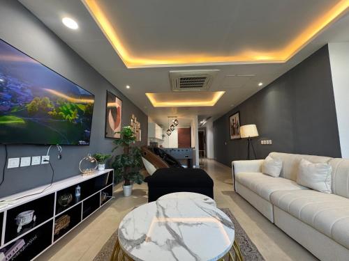 a living room with a couch and a tv at Gold Crest Executive Hotel Apartments City View DHA Lahore in Lahore