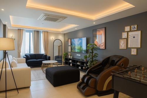 a living room with a couch and a tv at Gold Crest Executive Hotel Apartments City View DHA Lahore in Lahore