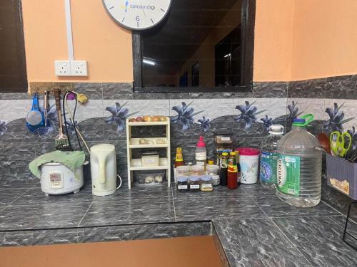 a kitchen counter with a counter top with a clock at Mysara Homestay Batu Gajah Tanah Merah in Tanah Merah