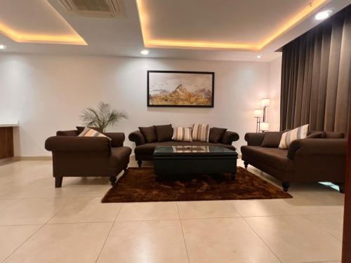 a living room with two couches and a coffee table at Gold Crest Executive Hotel Apartments City View DHA Lahore in Lahore