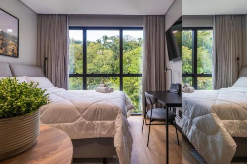 ein Hotelzimmer mit zwei Betten und einem Fenster in der Unterkunft Edificio Village Lofts - Ao lado da Vila Germânica in Blumenau