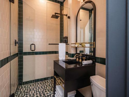 a bathroom with a sink and a toilet and a mirror at Balfour Miami Beach, a Morgans Originals hotel in Miami Beach