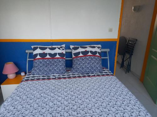 a bedroom with a bed with blue and white sheets and pillows at Martinique 3 ILETS POINTE DU BOUT T2 35M2 in Les Trois-Îlets