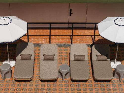 a group of chairs and a table with an umbrella at Balfour Miami Beach, a Morgans Originals hotel in Miami Beach