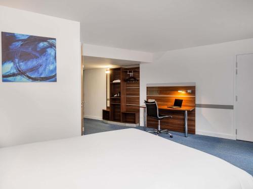 a bedroom with a bed and a desk with a laptop at Hôtel Marseille Centre Gare Saint-Charles in Marseille
