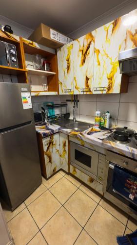 a kitchen with a dirty kitchen with a refrigerator at Metro Santa Ana 2 dormitorios wifi check in tardío in Santiago