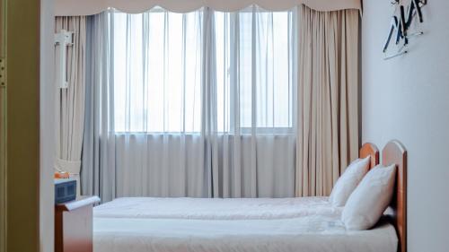 Postel nebo postele na pokoji v ubytování Busan Central Hotel