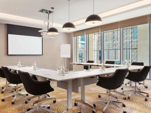 a conference room with a large table and chairs at Novotel Dubai Gold District in Dubai