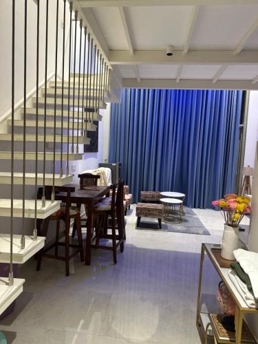 a living room with a table and a blue curtain at Loft 74 Studio's in Gurgaon