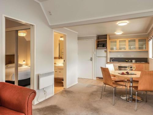 a kitchen and living room with a table and chairs at Wairakei Resort Taupo in Taupo