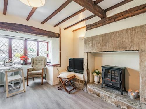 - un salon avec une cheminée et un bureau dans l'établissement Halcyon Cottage, à Deepcar