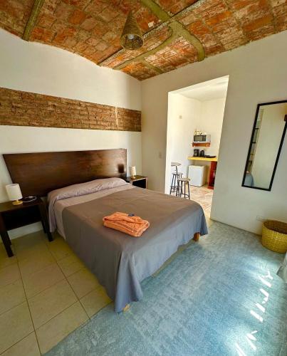 a bedroom with a bed and a brick wall at LUNA Loft, Aguascalientes Downtown in Aguascalientes
