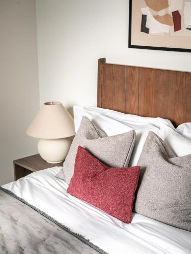 a bed with three red pillows on it at Urban Rest Bermondsey in London
