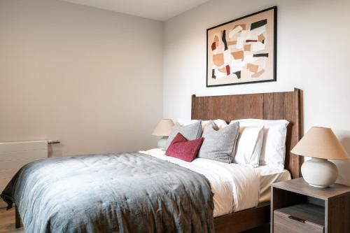 a bedroom with a bed with white sheets and red pillows at Urban Rest Bermondsey in London