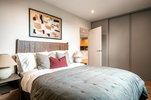 a bedroom with a large bed with red pillows at Urban Rest Bermondsey in London