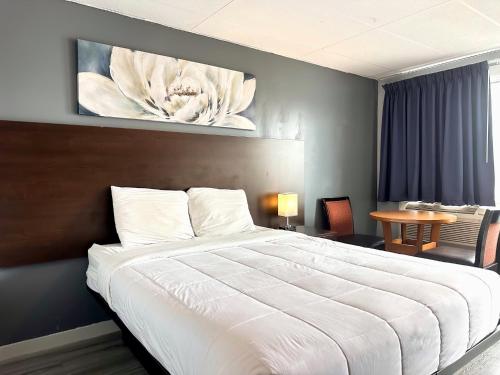 a bedroom with a large white bed and a table at Elect Inn 5 in Cornwall