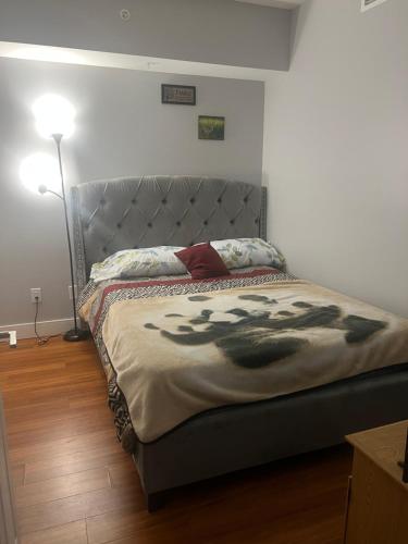 ブラントフォードにあるHomey Stay in Brantfordのベッドルーム1室(大型ベッド1台、金属製ヘッドボード付)