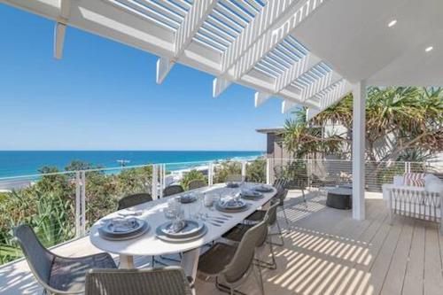 a white table and chairs on a deck with the ocean at Seaviews at Sunshine Beach 4BR, Pool in Sunshine Beach