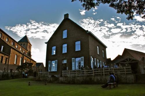 a person sitting on a bench in front of a building at De Oude Pastorij in Maarkedal