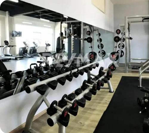 a gym with dumbbells and weights on a wall at Hermosa SUITE vista increíble, gym, elevador in Mexico City