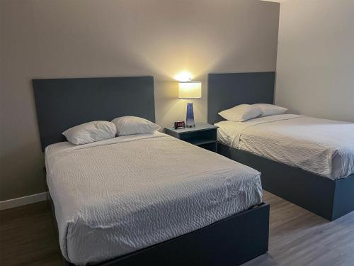 a bedroom with two beds and a table with a lamp at Motel 6 Merritt, BC in Merritt