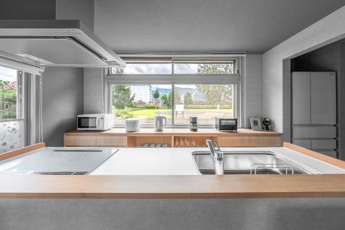 富良野市にあるThe ARBANOのシンクと大きな窓のあるキッチン