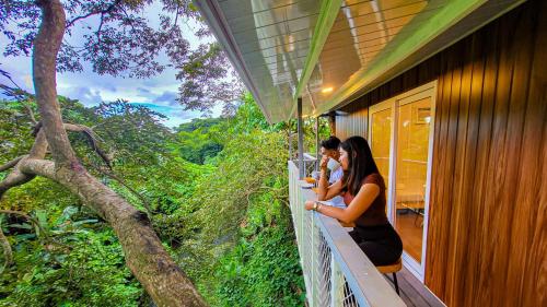 two people sitting on a balcony of a house at Mancion Bakasyunan Resort and Conference Center San Pablo, Laguna in San Pablo