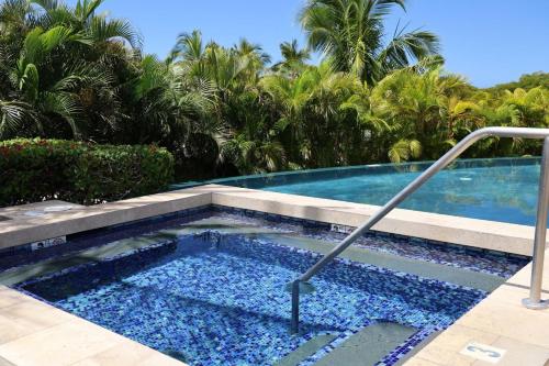a swimming pool in a resort with palm trees at ❤PiH❤ Endless Ocean Views Villa Gorgeous Mauna Kea Ocean and Mountain View in Hapuna Beach