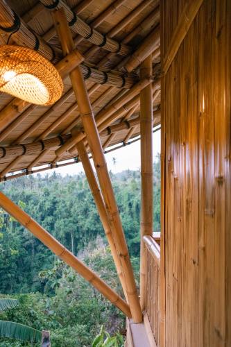 a wooden house with a view of the forest at Damuh Alam in Lovina