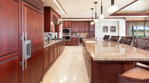 a large kitchen with wooden cabinets and a large island at ❤PiH❤ Ikena Nani Ocean Coastline Views Mauna Kea Resort in Waimea