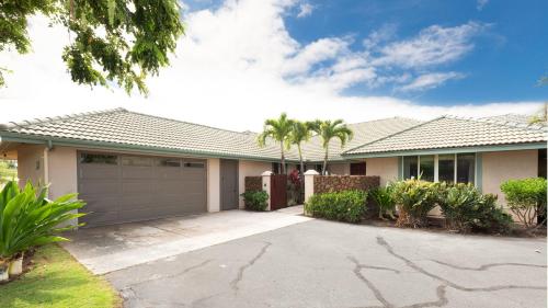 a house with a garage and palm trees at ❤PiH❤ Ikena Nani Ocean Coastline Views Mauna Kea Resort in Waimea