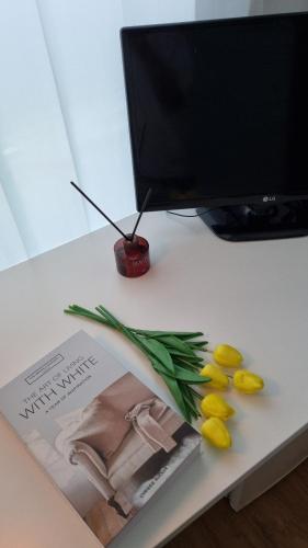 a table with a magazine and some flowers and fruit at Huestay Gumdan in Incheon