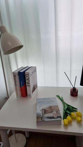 a table with a lamp and books and flowers on it at Huestay Gumdan in Incheon