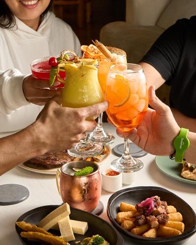 a group of people sitting at a table with drinks at Dreamer Cocora in Salento