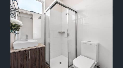 a bathroom with a shower and a toilet and a sink at See the light in Melbourne