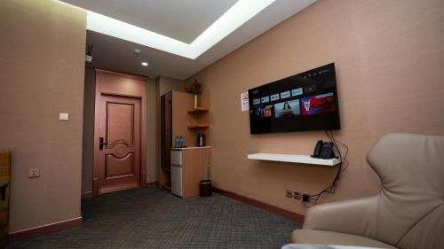 a room with a tv on a wall with a door at Amgun Hotel Ulaanbaatar in Ulaanbaatar