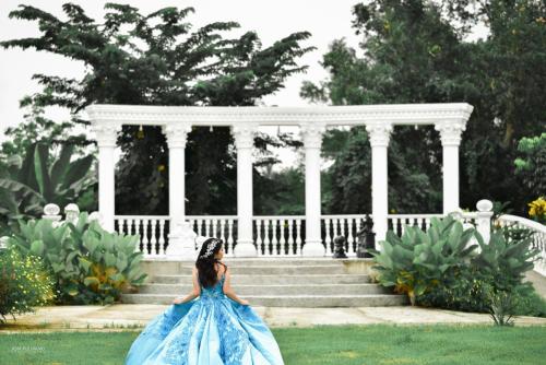 a woman in a blue dress standing in front of a building at Mancion Bakasyunan Resort and Conference Center San Pablo, Laguna in San Pablo