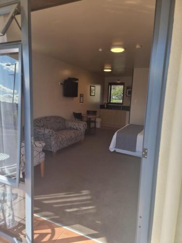 a view of a room with a bed and a couch at Broadway Motel in Picton