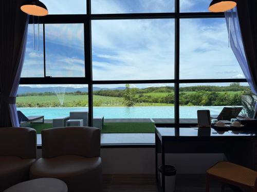 a room with a large window with a view of a lake at GrandWara Khao Yai แกรนด์วารา เขาใหญ่ in Ban Nong Song Hong