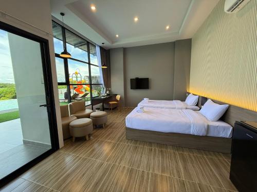 a bedroom with a bed and a large window at GrandWara Khao Yai แกรนด์วารา เขาใหญ่ in Ban Nong Song Hong