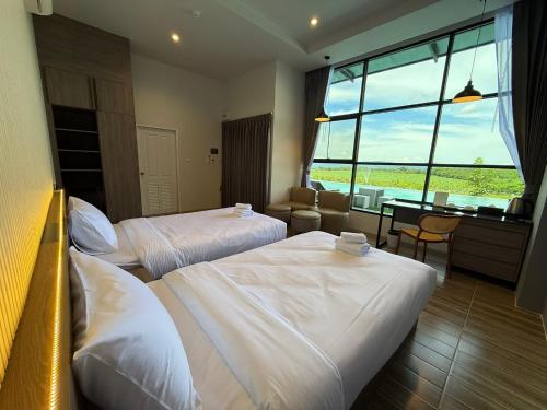 a hotel room with two beds and a desk at GrandWara Khao Yai แกรนด์วารา เขาใหญ่ in Ban Nong Song Hong