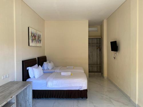 a hotel room with a bed and a television at THE LAVIANA HOTEL in Lovina