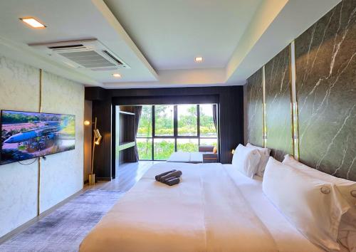 une chambre avec un grand lit blanc dans une pièce dans l'établissement See Stars & Forest Resort, à Amphoe Sawang Daen Din