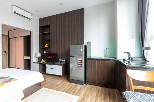 een keuken met een koelkast en een wastafel in de kamer bij Ivy Luxury Hotel Ha Noi in Hanoi