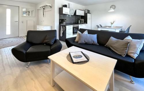 Una sala de estar con un sofá negro y una mesa. en Ferienhaus Fuhlendorf, en Fuhlendorf