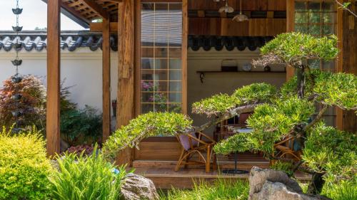 a wooden porch with a chair and some plants at Floral Hotel Tengchong Wuwenju B&B in Tengchong