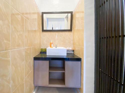 a bathroom with a sink and a mirror at Sans Vibes Tendan Residence Kuta in Legian