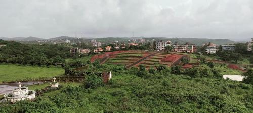 a view of a park with buildings on a hill at Harekar Holiday Homes in Dapoli
