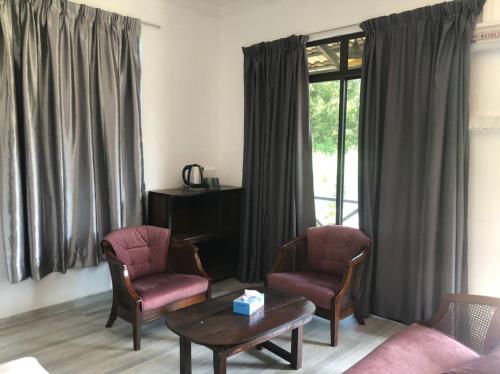 a living room with two chairs and a coffee table at Kalong Bay Homestay Villa Jasmine in Kijal