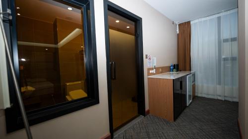 a bathroom with a shower and a sink and a mirror at Amgun Hotel Ulaanbaatar in Ulaanbaatar